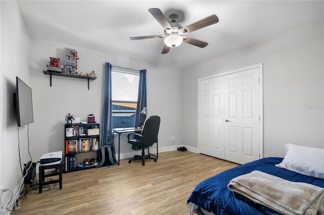 bedroom with a closet, light hardwood / wood-style flooring, and ceiling fan