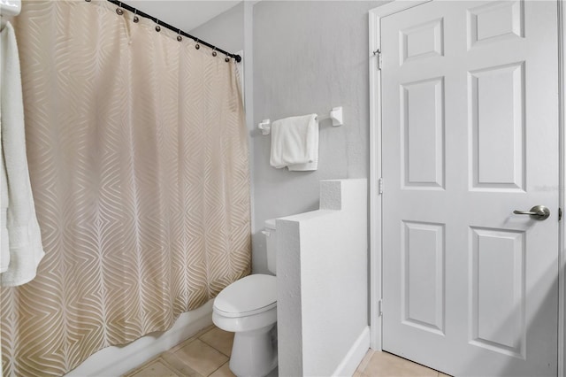 bathroom with tile patterned flooring, shower / bath combo, and toilet