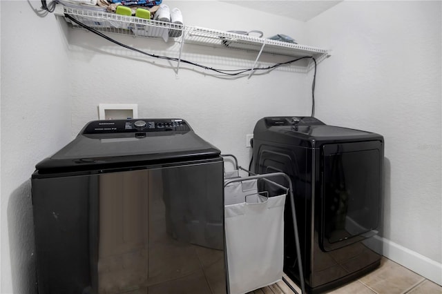 washroom featuring washer and clothes dryer and light tile patterned floors