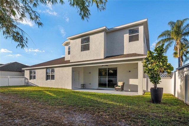 back of property featuring a lawn and a patio area