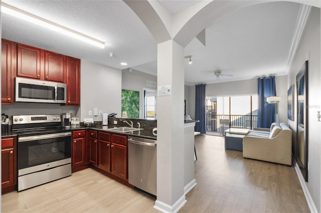 kitchen with dark countertops, dark brown cabinets, and appliances with stainless steel finishes