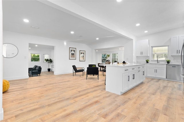 kitchen featuring a wealth of natural light, white cabinetry, and stainless steel dishwasher