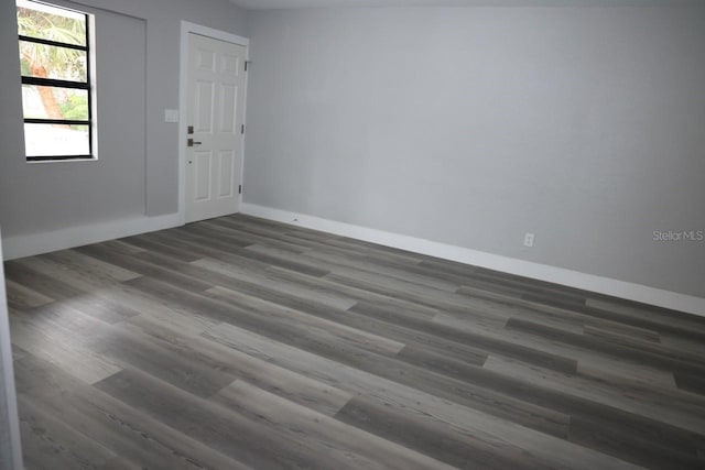 empty room with dark hardwood / wood-style flooring