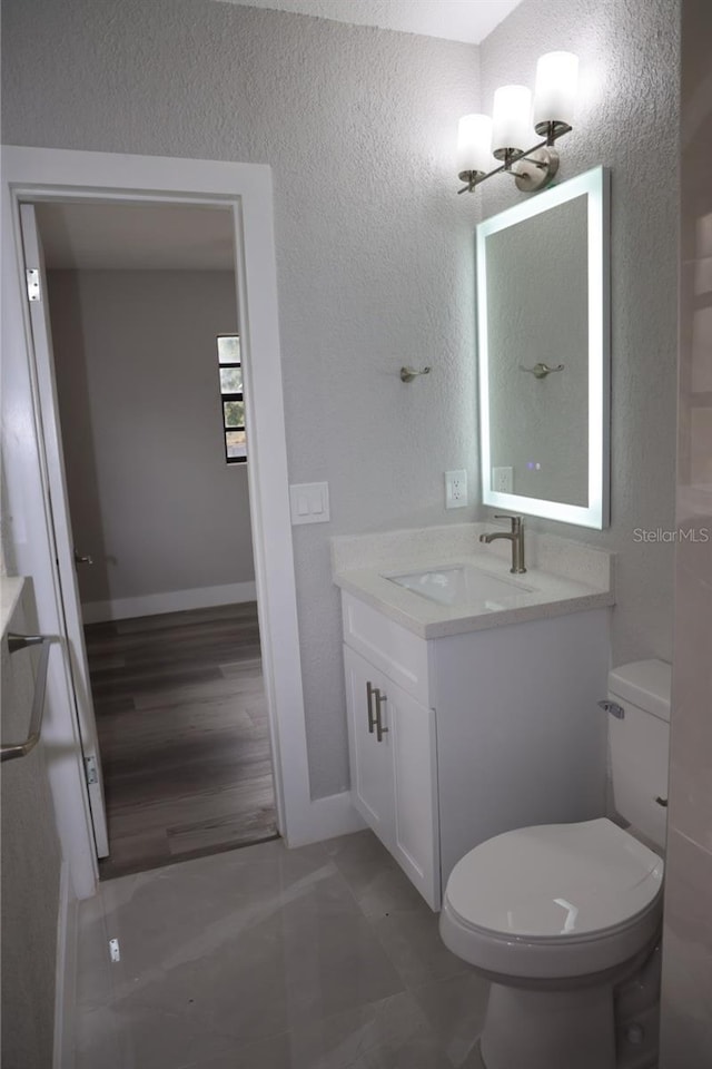 bathroom featuring hardwood / wood-style floors, vanity, and toilet