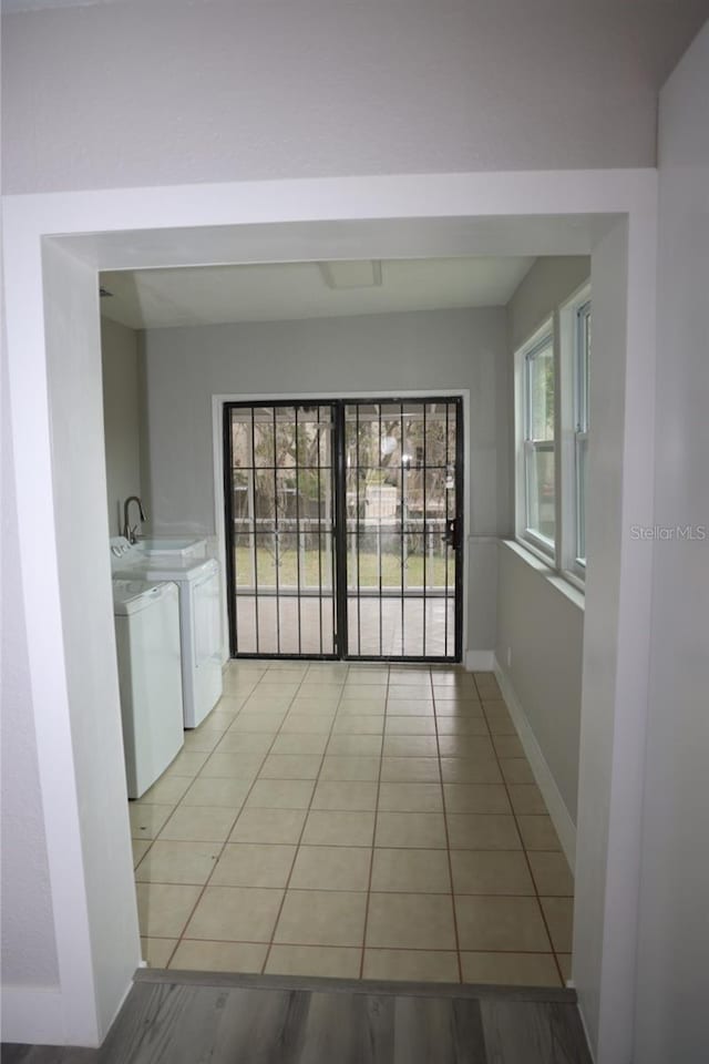 hall featuring washer and clothes dryer and light tile patterned floors