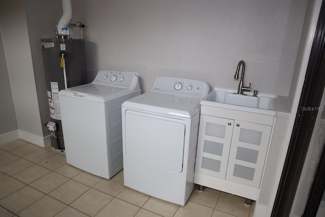 clothes washing area featuring cabinets, sink, washer and dryer, water heater, and light tile patterned flooring