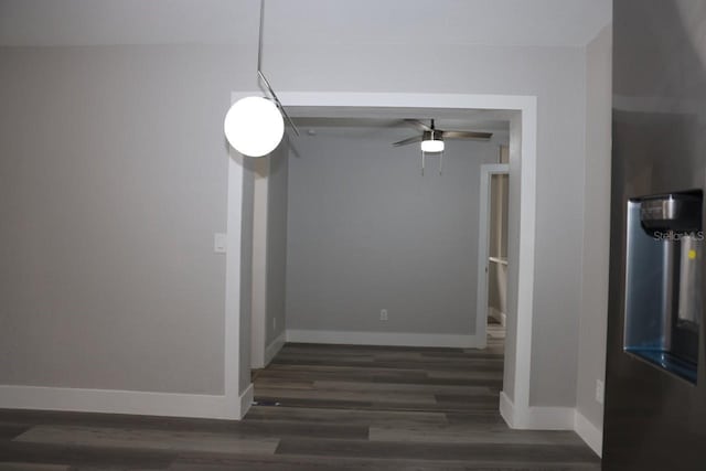 unfurnished dining area featuring ceiling fan and dark wood-type flooring