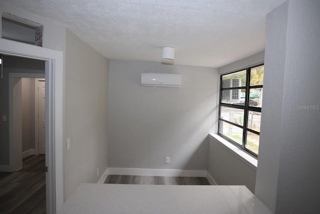 stairway featuring hardwood / wood-style floors, an AC wall unit, and a textured ceiling