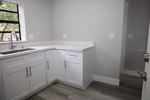 kitchen featuring white cabinets, dark hardwood / wood-style flooring, and sink