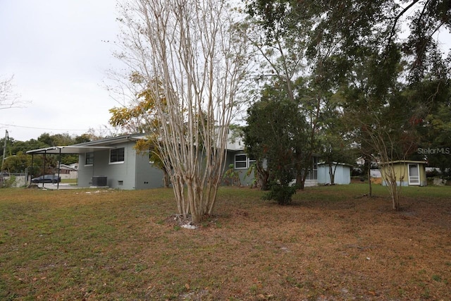 view of yard with central AC and a carport