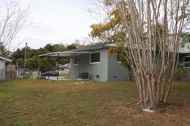 exterior space with a carport, cooling unit, and a lawn