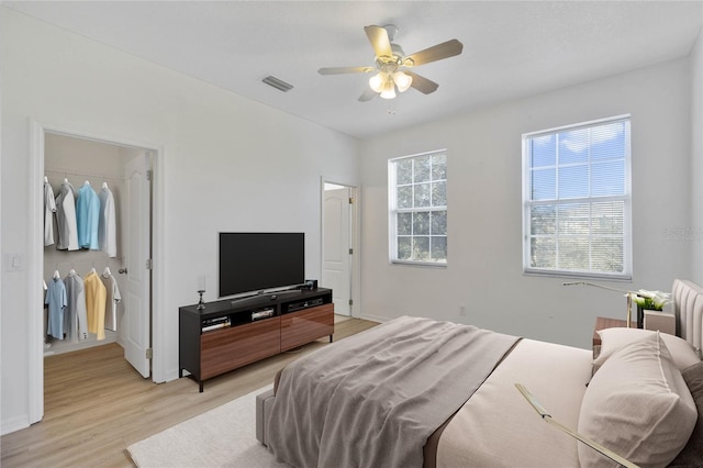 bedroom featuring ceiling fan, light wood-type flooring, radiator, and a closet