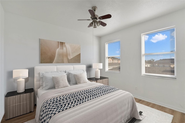 bedroom with ceiling fan and light hardwood / wood-style flooring