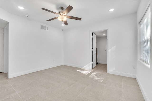 tiled empty room featuring ceiling fan