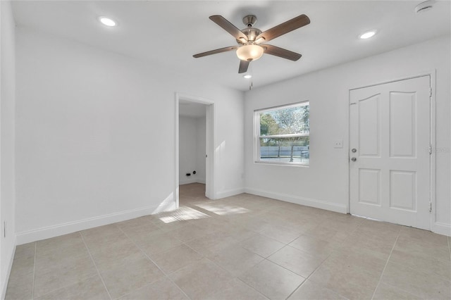 tiled spare room featuring ceiling fan