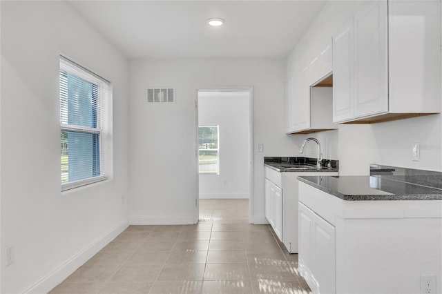 kitchen featuring sink, white cabinets, and light tile patterned flooring