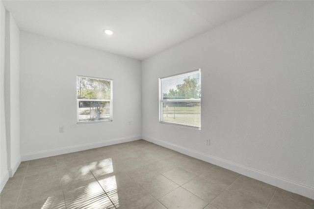 spare room featuring a wealth of natural light and light tile patterned flooring