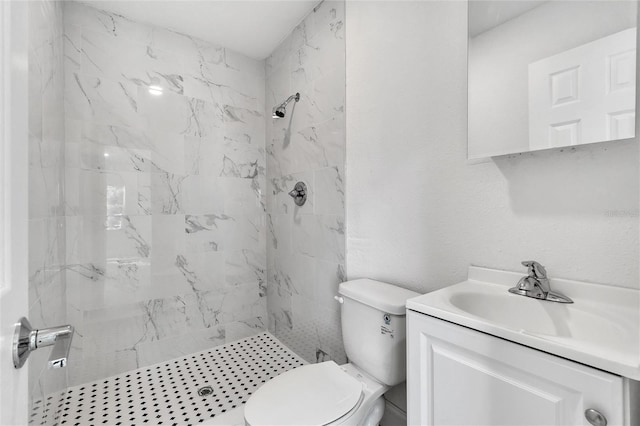 bathroom with vanity, toilet, and a tile shower