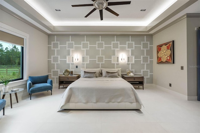 bedroom with a tray ceiling and ceiling fan