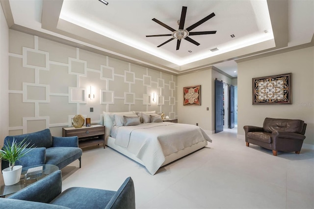 bedroom with ceiling fan and a tray ceiling