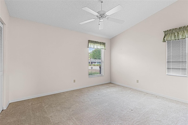 unfurnished room with ceiling fan, light colored carpet, and a textured ceiling