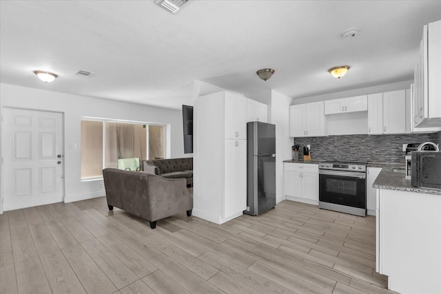 kitchen featuring appliances with stainless steel finishes, tasteful backsplash, white cabinetry, light hardwood / wood-style floors, and light stone countertops