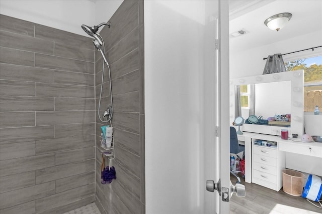 bathroom featuring wood-type flooring and a tile shower