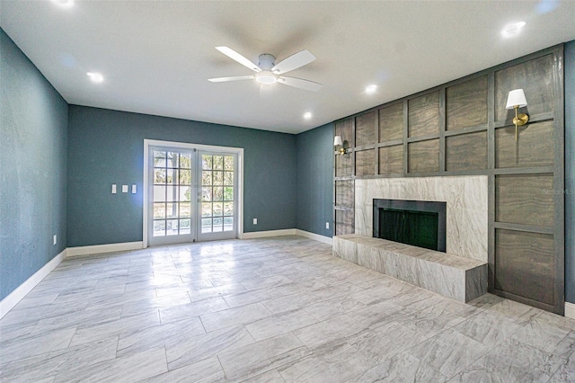 unfurnished living room with recessed lighting, ceiling fan, baseboards, and a fireplace