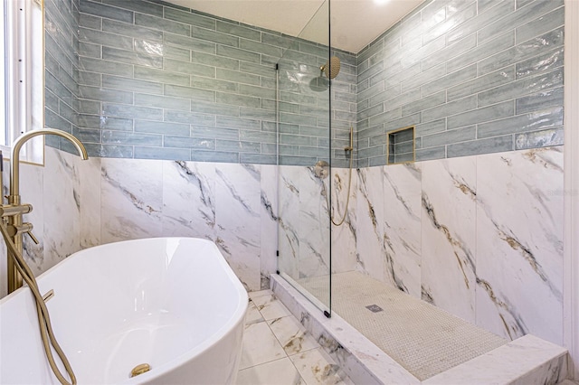 full bathroom with a freestanding bath, tile walls, a marble finish shower, and marble finish floor
