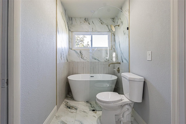 full bathroom with walk in shower, toilet, marble finish floor, a textured wall, and a soaking tub