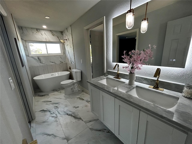 bathroom with double vanity, a freestanding tub, a sink, and marble finish floor