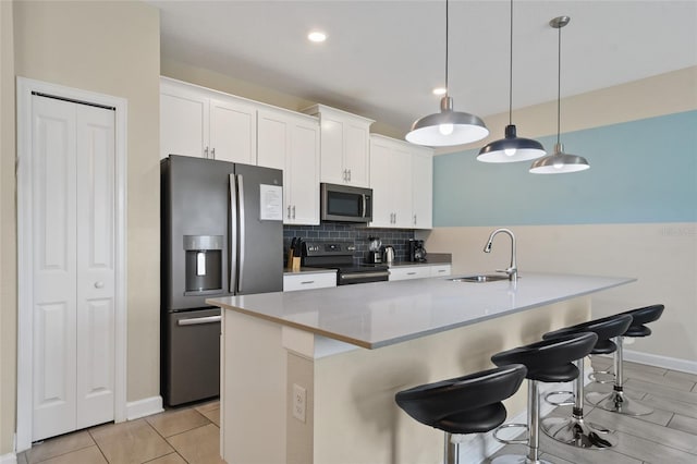 820 Pebble Beach Dr, Davenport, FL 33896 - kitchen with appliances with stainless steel finishes, a breakfast bar, white cabinetry, backsplash, and recessed lighting