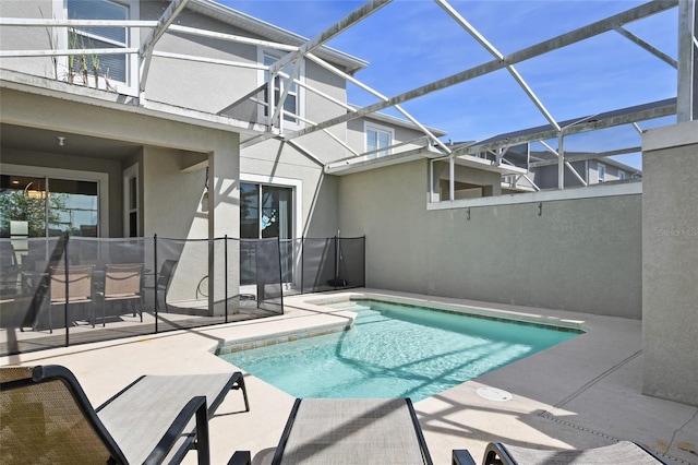 view of swimming pool featuring glass enclosure and a patio