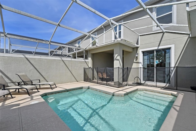 view of pool with glass enclosure and a patio