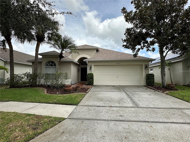 view of front of home featuring a garage and a front lawn