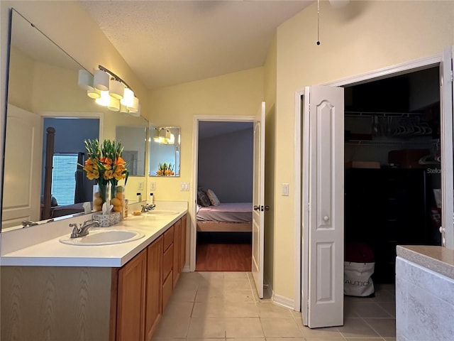 bathroom featuring tile patterned floors, a textured ceiling, vanity, and vaulted ceiling