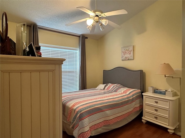 bedroom featuring a textured ceiling, dark hardwood / wood-style flooring, vaulted ceiling, and ceiling fan