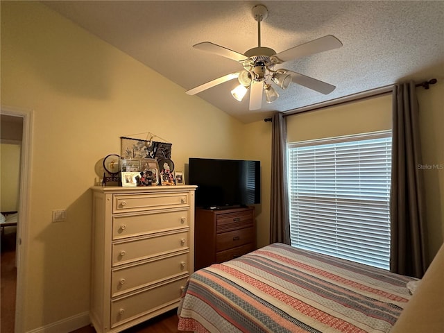 bedroom featuring a textured ceiling, vaulted ceiling, and ceiling fan