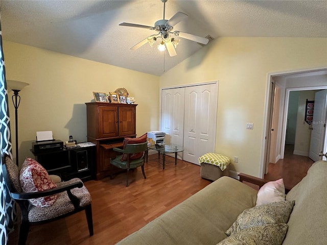 office featuring a textured ceiling, ceiling fan, hardwood / wood-style floors, and vaulted ceiling