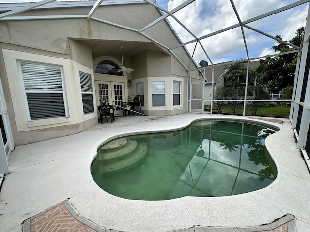 view of swimming pool featuring glass enclosure, ceiling fan, french doors, and a patio area