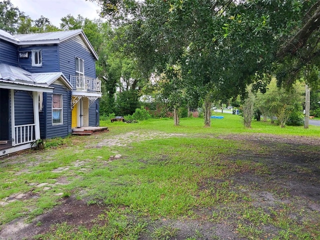 view of yard with a balcony