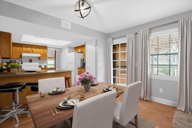 dining space with sink and light tile patterned flooring