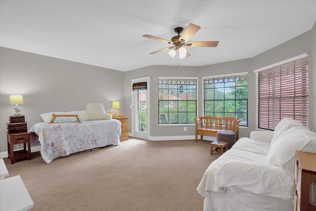 carpeted bedroom featuring ceiling fan and a textured ceiling