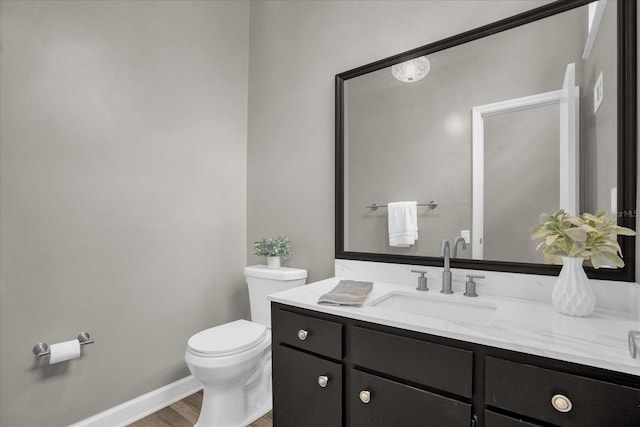 bathroom with vanity, toilet, and wood-type flooring