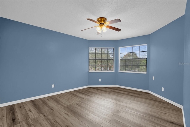 empty room with hardwood / wood-style floors, ceiling fan, and a textured ceiling