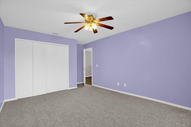 unfurnished bedroom featuring carpet floors, a closet, and ceiling fan