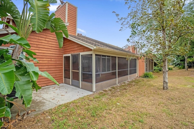 back of house with a lawn and a patio