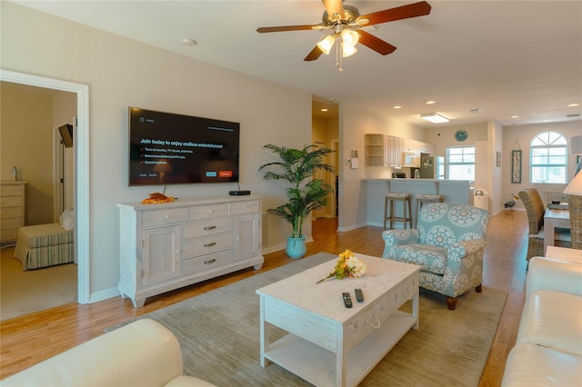 living room featuring ceiling fan and light hardwood / wood-style floors