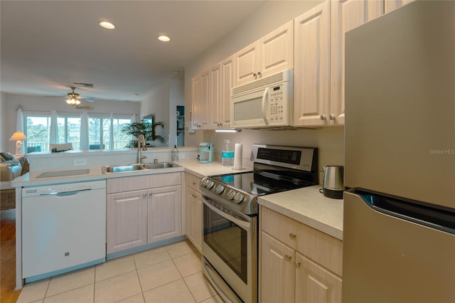 kitchen with kitchen peninsula, sink, light tile patterned floors, and appliances with stainless steel finishes