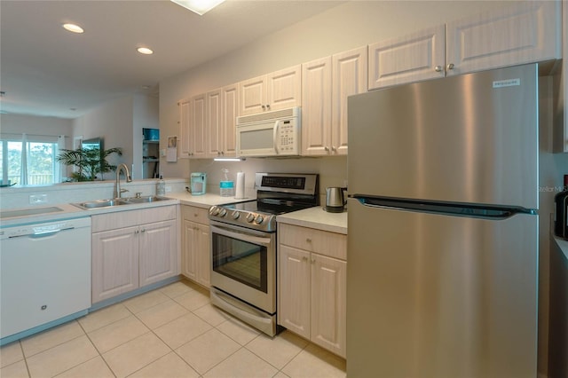 kitchen with white cabinets, sink, light tile patterned floors, and stainless steel appliances